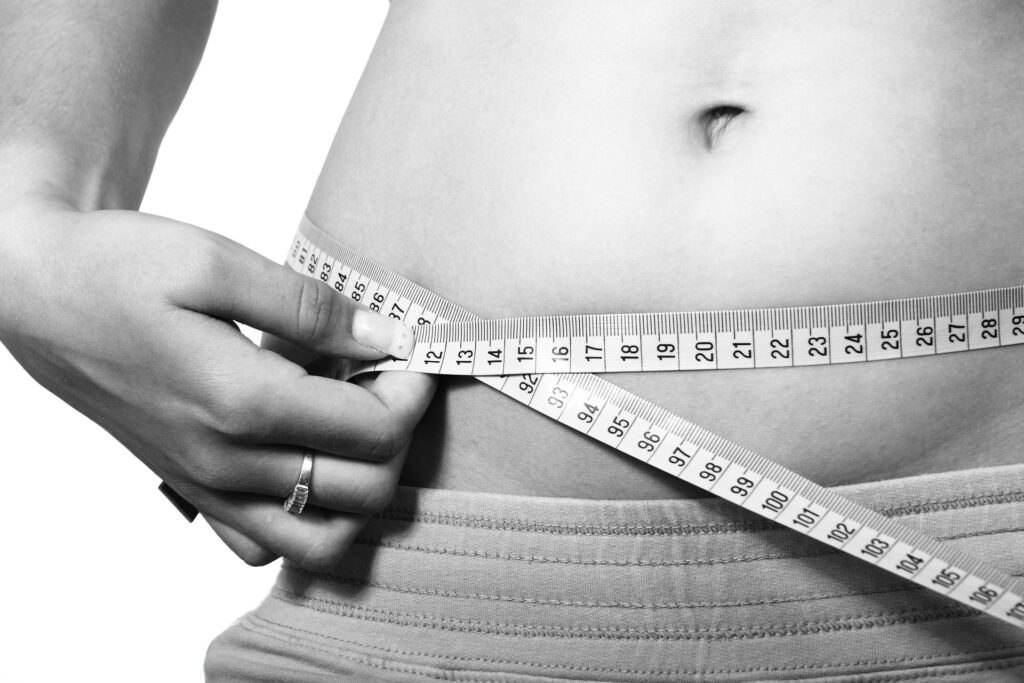 measuring tape around woman's stomach